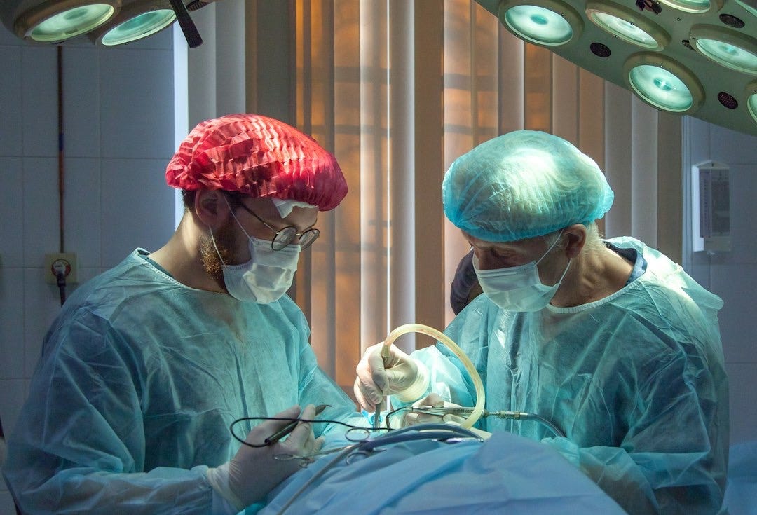 two men wearing blue lab coats two men wearing blue lab coats