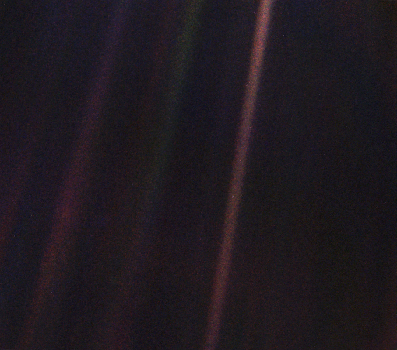 Earth as a small blue dot in a fuzzy beam of light. Earth as a small blue dot in a fuzzy beam of light.