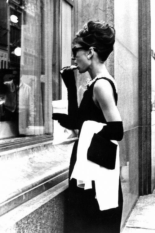 This may contain: a woman standing in front of a window