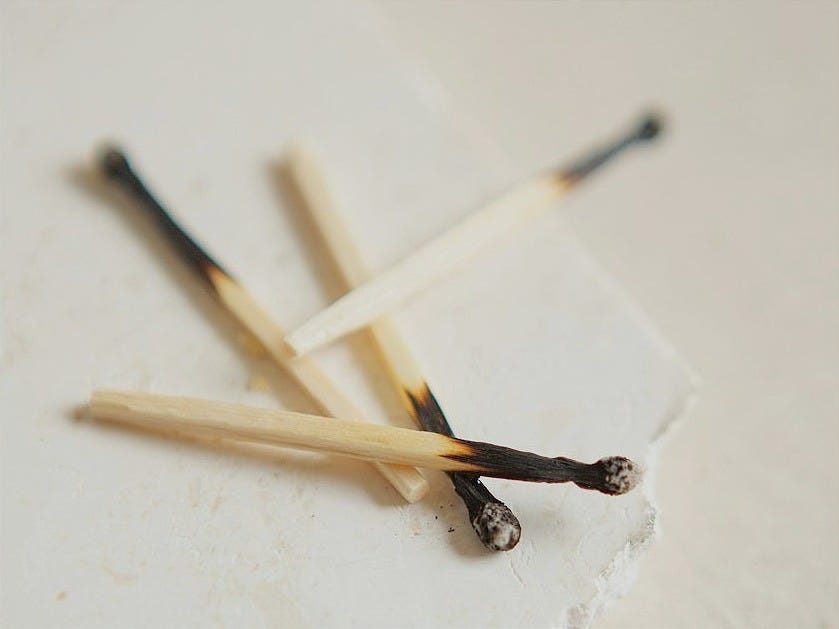 burnt wooden matchsticks on white surface