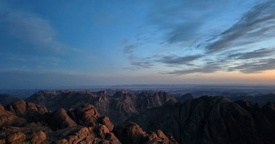 Mountains are seen under a beautiful, cloudy sky.