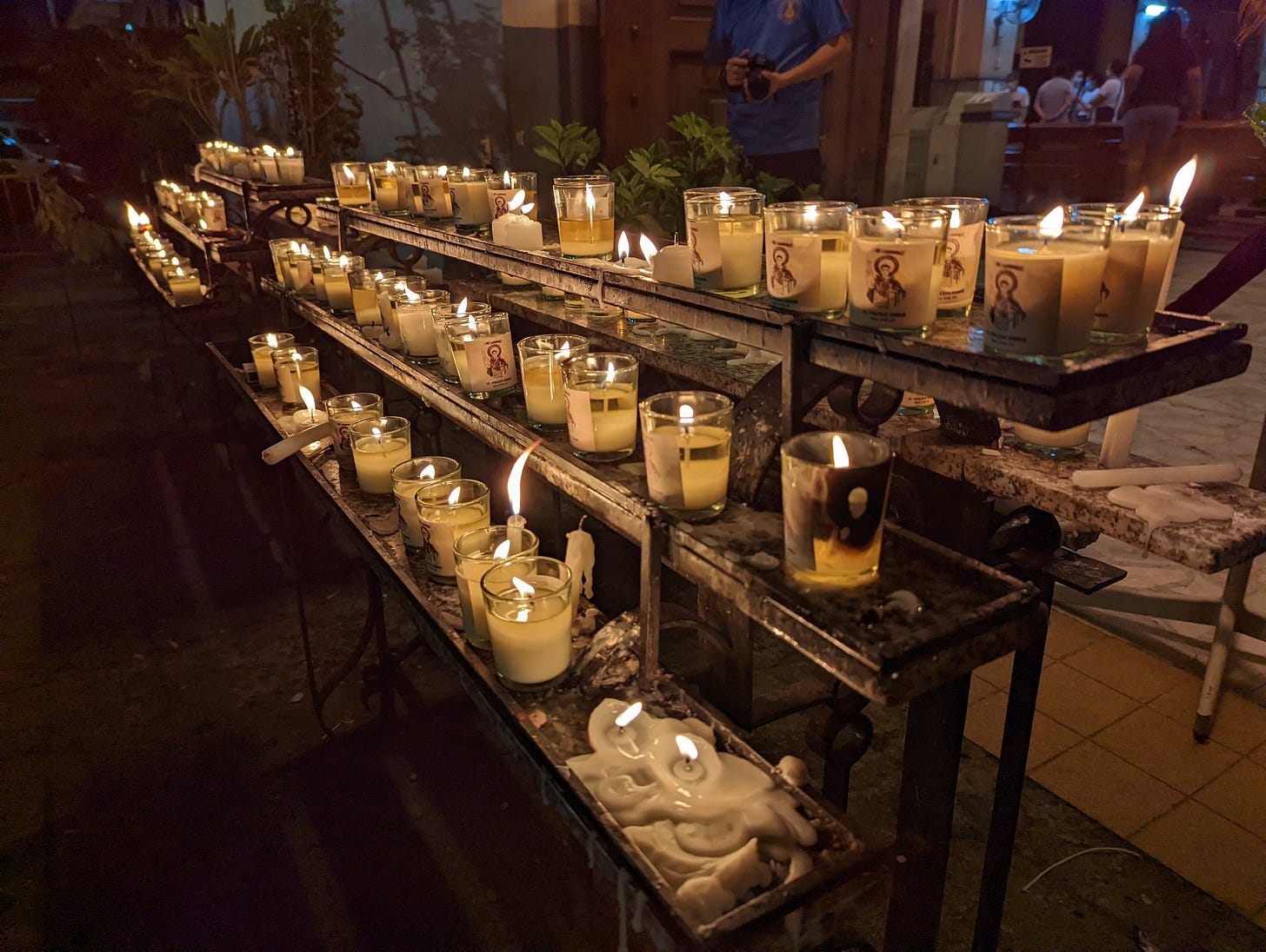 The two candle stations found on the entrance of Santo Domingo Church showing rows of lit candles