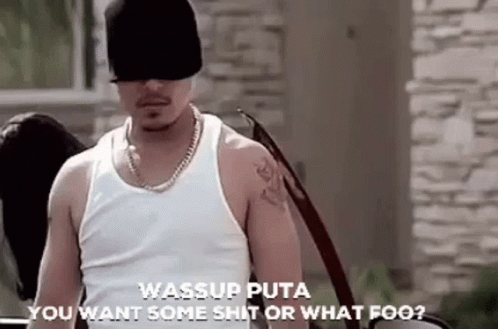 a man wearing a hat and sunglasses is standing next to a car and talking to someone .