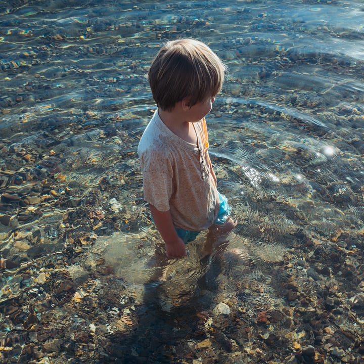 Amelia Teresa holds my rosary while falling asleep. Leon walking through the water.