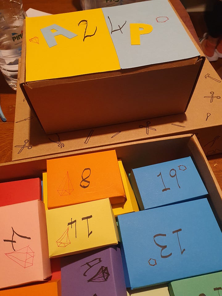 Two boxes filled with smaller colourful cardboxes