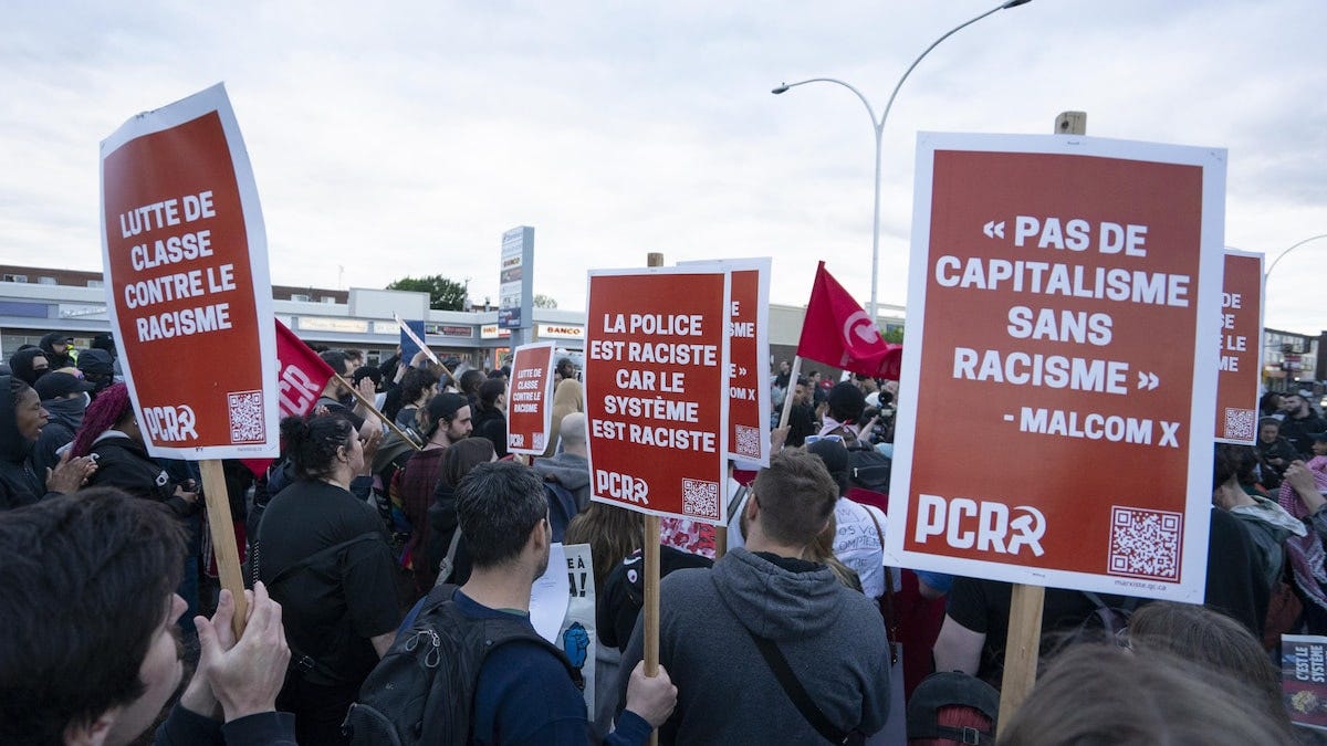 Des gens tiennent des pancartes sur lesquelles il est écrit "Pas de capitalisme sans racisme". 