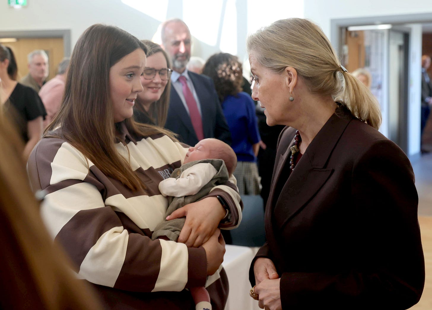 Duchess Sophie standing next to a girl holding a baby