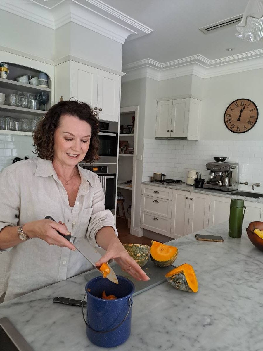Jo chopping up food waste before putting it into the kitchen scrap bin