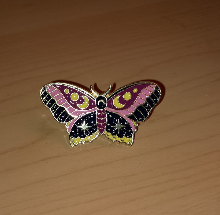 enamel cat with flowers and a butterfly decorated with stars and moons