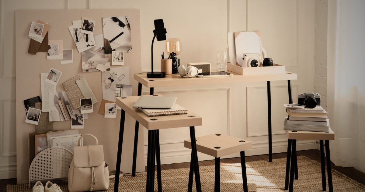 A consultant's workspace with tiered desks, a mood board covered in pinned photos and notes, and a laptop open mid-session, reflecting the creative thinking an independent consultant brings to understanding their reader before writing.