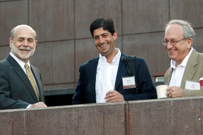 Ben Bernanke, Kevin Warsh, and Donald Kohn smile on a veranda.
