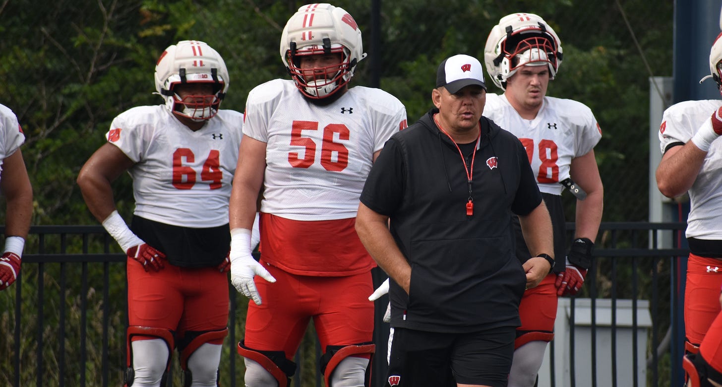 Wisconsin Badgers offensive line coach A.J. Blazek instructing offensive linemen on the practice field at UW–Platteville for fall camp. Wisconsin Badgers offensive line coach A.J. Blazek instructing offensive linemen on the practice field at UW–Platteville for fall camp.