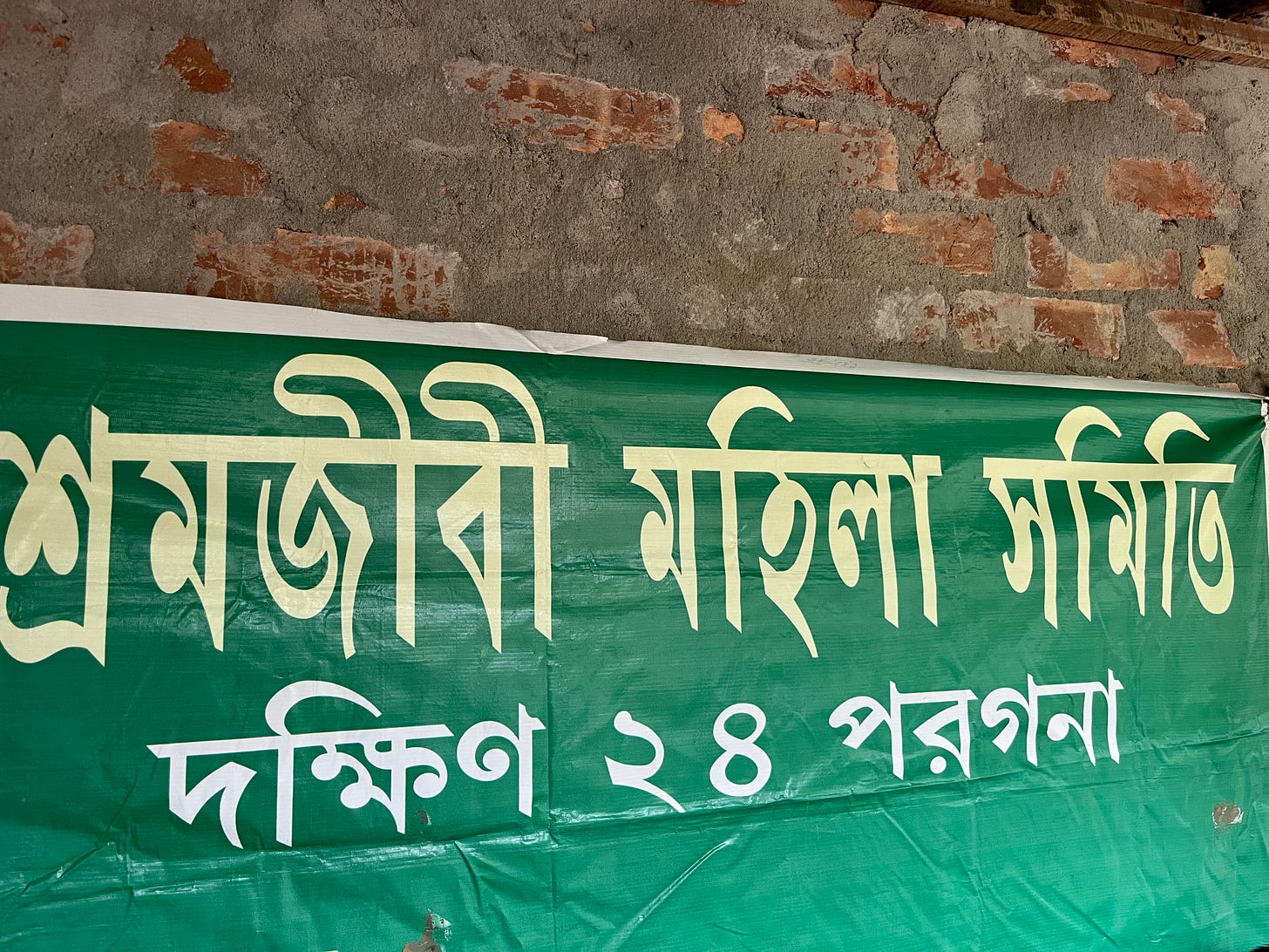 A green flex banner announcing the office of the Sramajibi Mahila Samiti