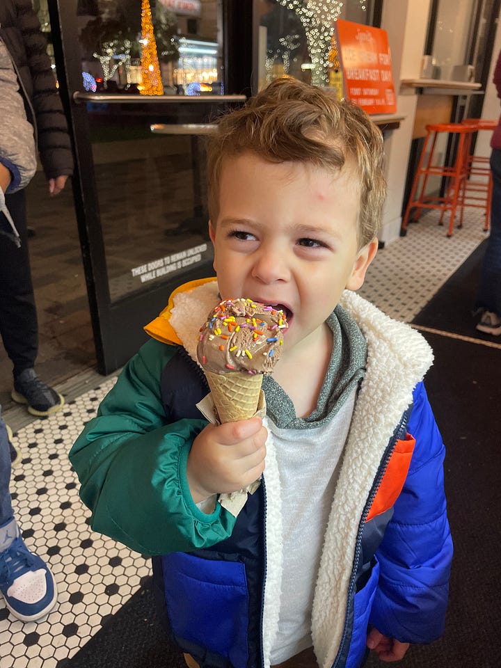A boy on the left smiling in front of magnetic tiles with his teddy bears, and a boy on the right eating a chocolate ice cream with sprinkles