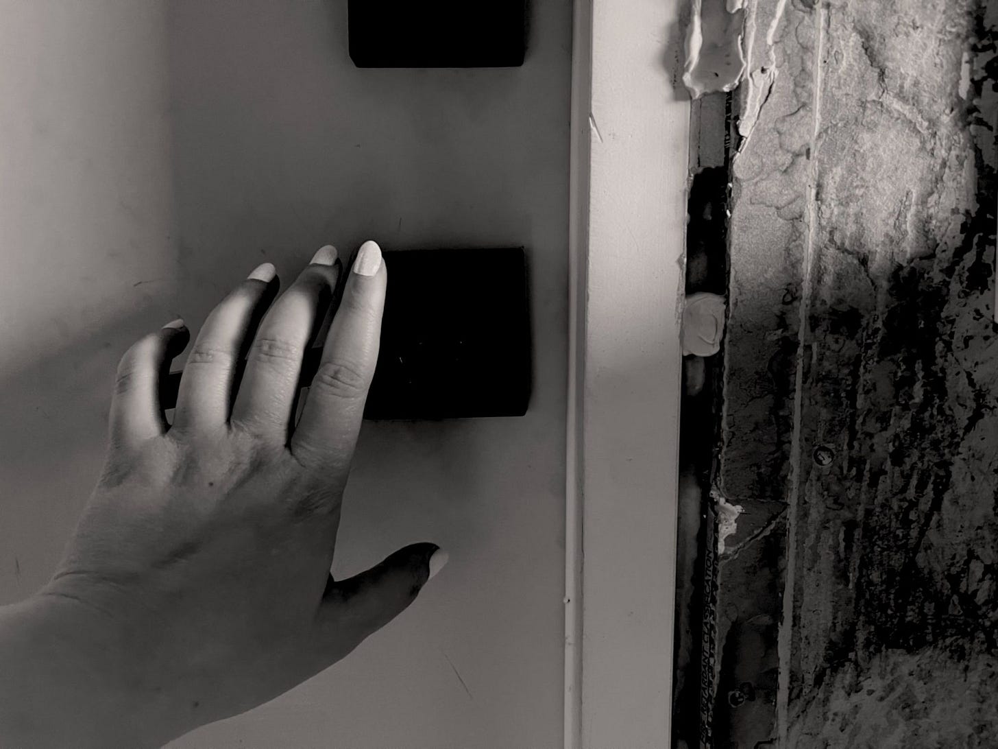 A person’s hand reaches for a door. (Credit: Mike LaSusa) 