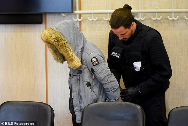 Bulgarian national Ilia K., 24, (pictured) was led into courtroom 12E of the Frankfurt Regional Court in handcuffs today to face charges of rape and bodily harm against his 19-year-old girlfriend Bulgarian national Ilia K., 24, (pictured) was led into courtroom 12E of the Frankfurt Regional Court in handcuffs today to face charges of rape and bodily harm against his 19-year-old girlfriend