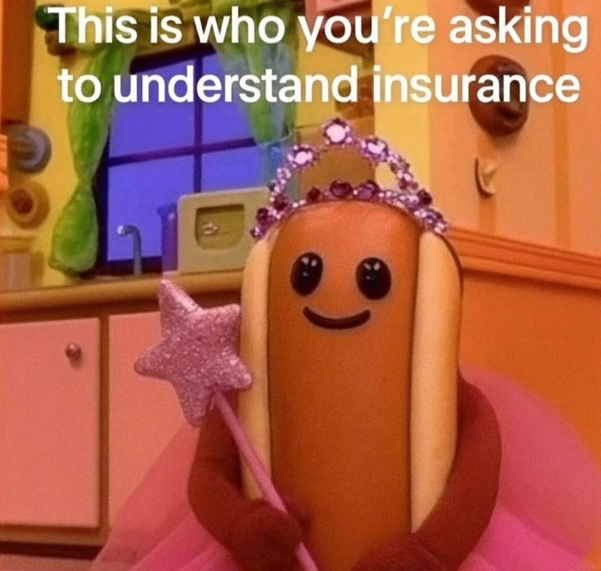 A hotdog character wearing a pink tutu, a purple crown with jewels, and holding a star-tipped wand, standing in a colorful kitchen setting with cabinets and a window. The text "This is who you\'re asking to understand insurance" is overlaid on the image.