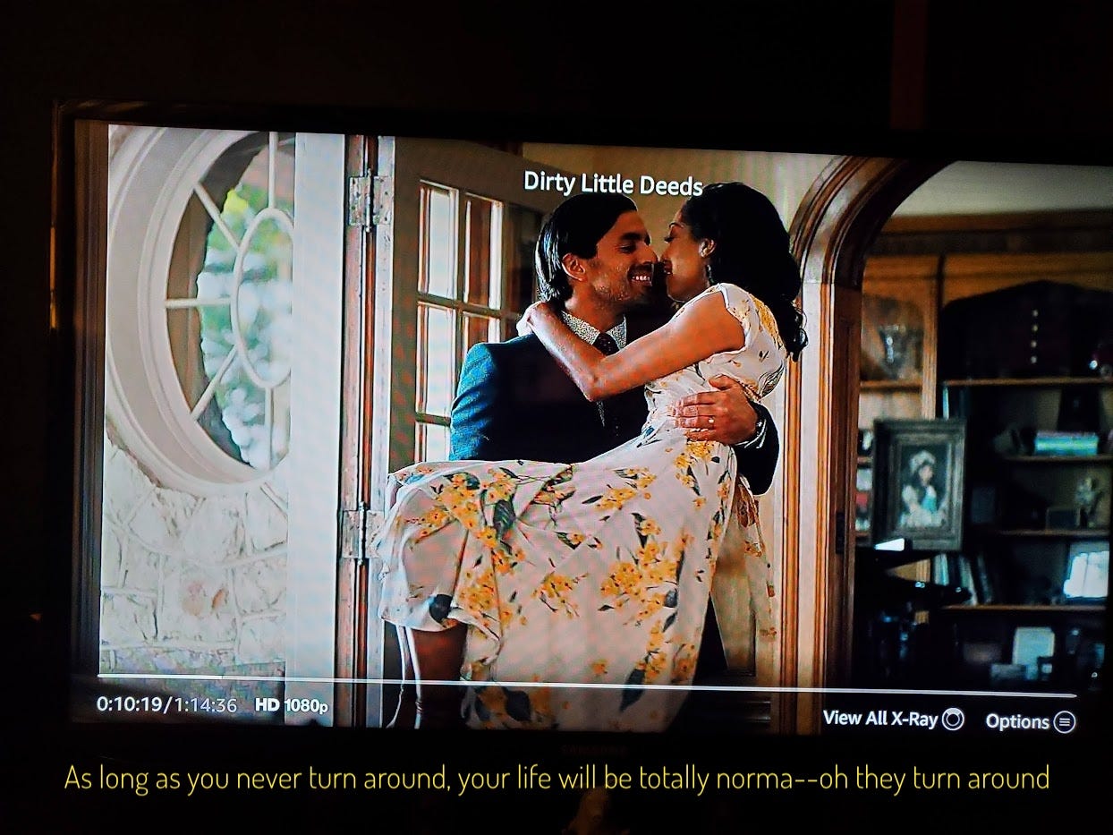 Simon, a swarthy white man in a suit, carrying Jessica, a light-skinned black woman in a floral dress, over the threshold. Captioned "As long as you never turn around, your life will be totally norma--oh they turn around"