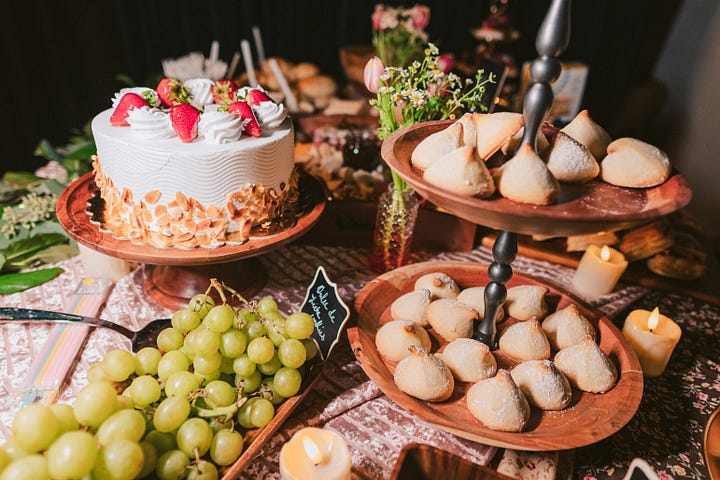 Cakes and treats abundantly displayed on a banquet table.