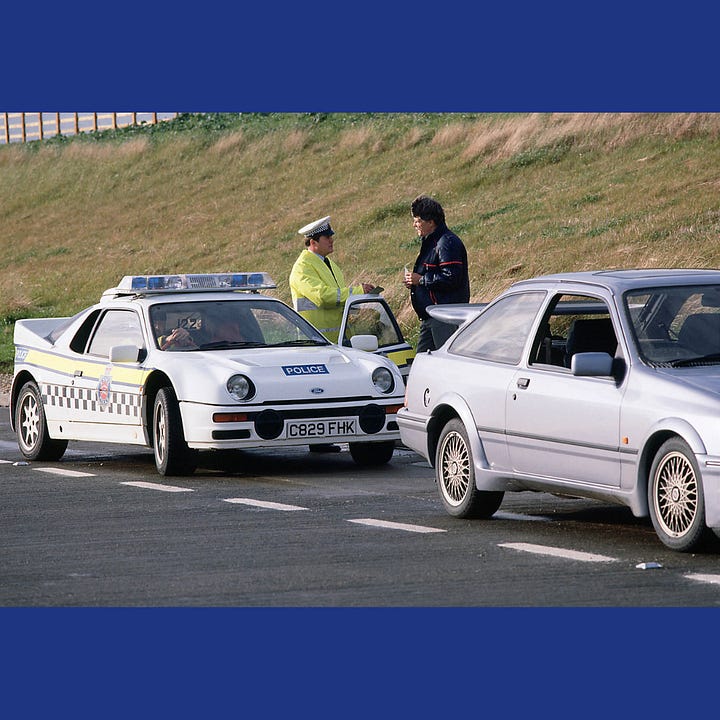 The RS200 'stops' a Cosworth Sierra in a layby on the A12.