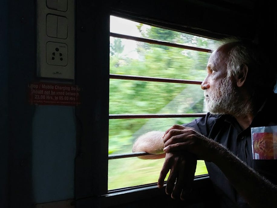 A man sitting in a train looking out the window