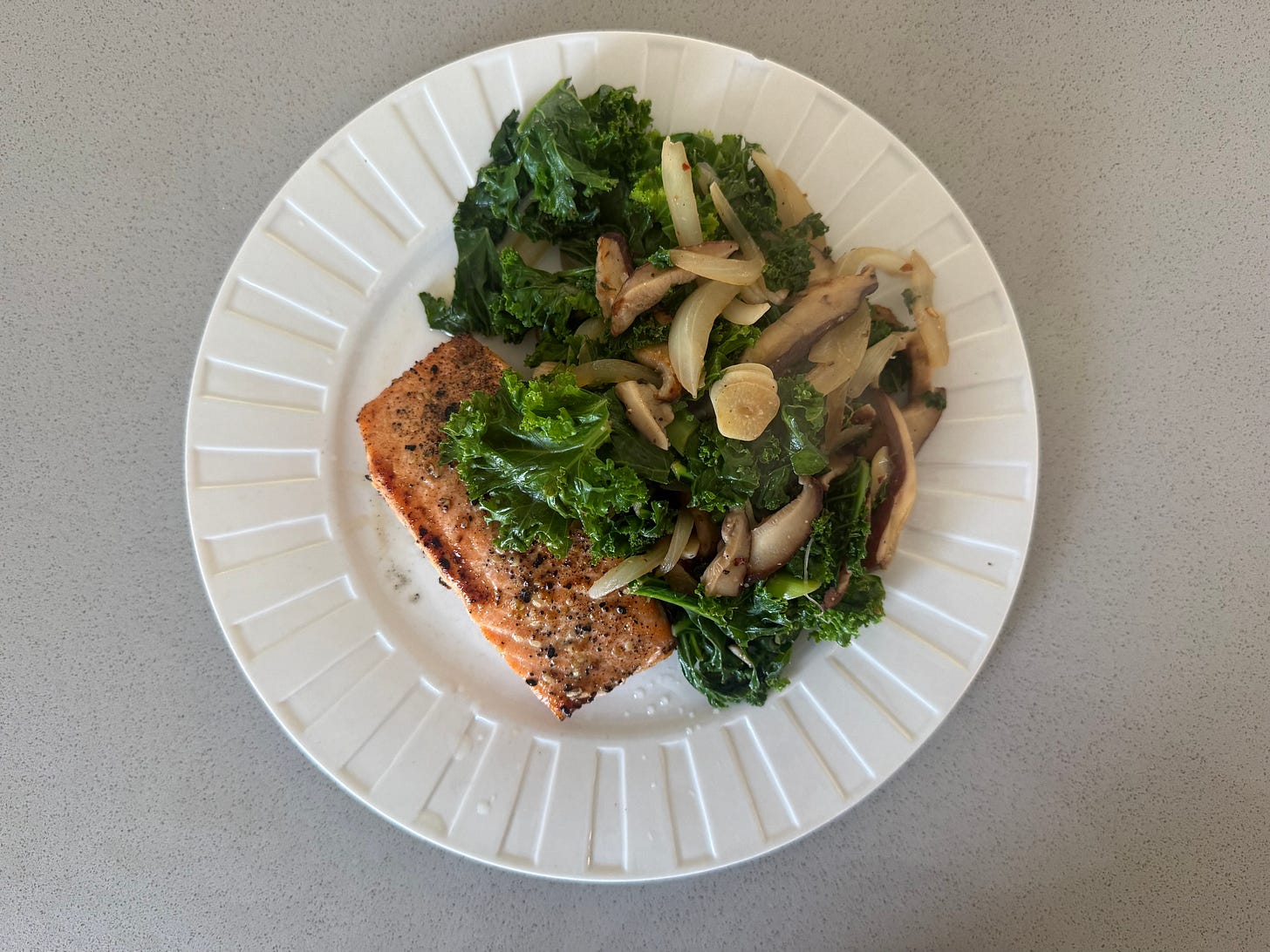 a warm lunch of pan-seared salmon and sauteed greens on a white plate — the rebellious midday pause that stops the grind. a warm lunch of pan-seared salmon and sauteed greens on a white plate — the rebellious midday pause that stops the grind.