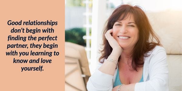 Smiling woman in her 40s with brown hair sitting on sofa showing healthy relationship with herself