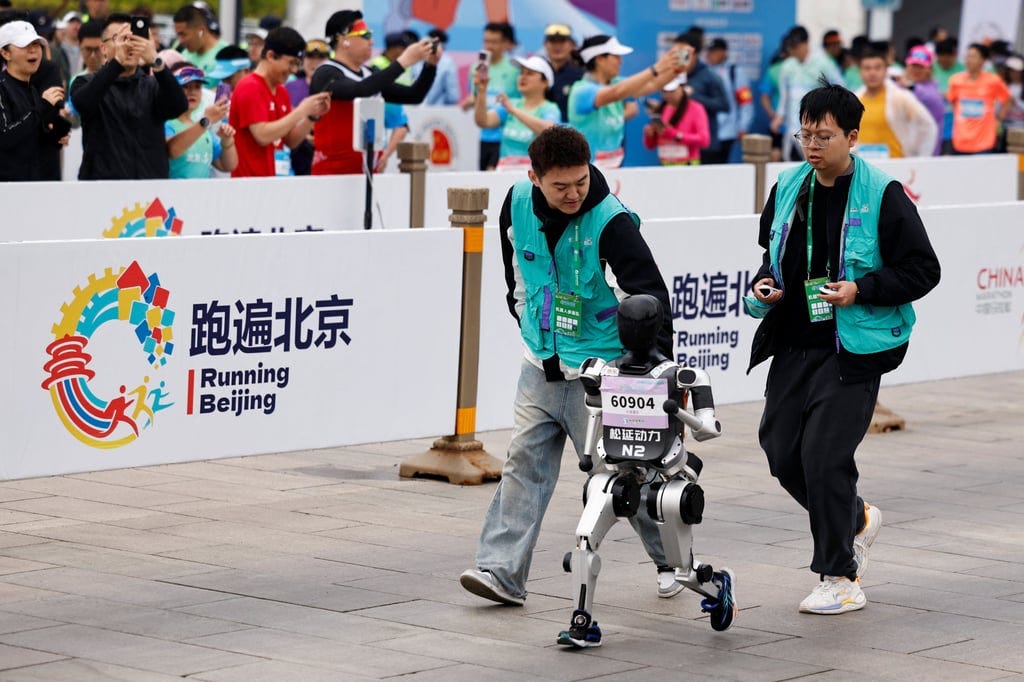 Engineers escort one of the smaller robots along the course. Photo: Reuters