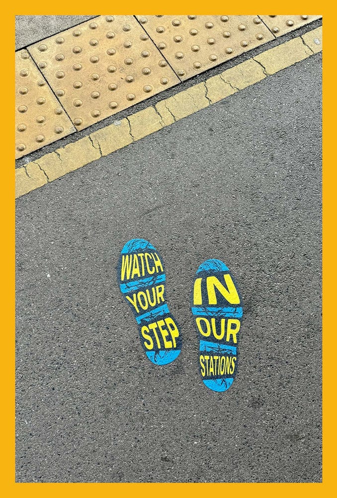 a sign on the station floor reading 'watch your step in our stations'