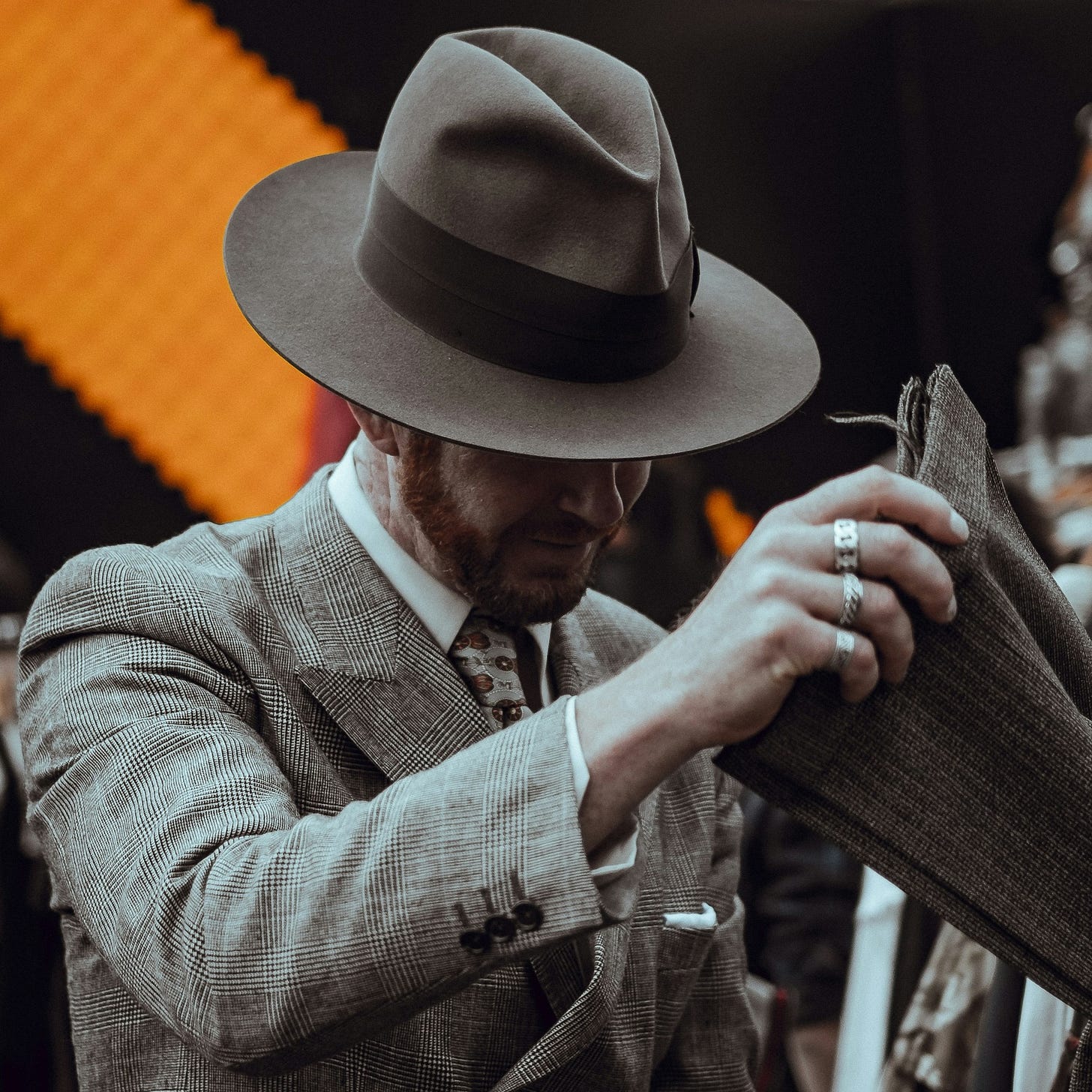A gentlemen in a suit with a fedora hat