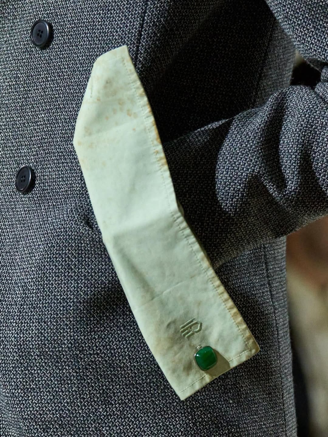 May be an image of duffle coat, overcoat, suit, blazer, neckwear and text