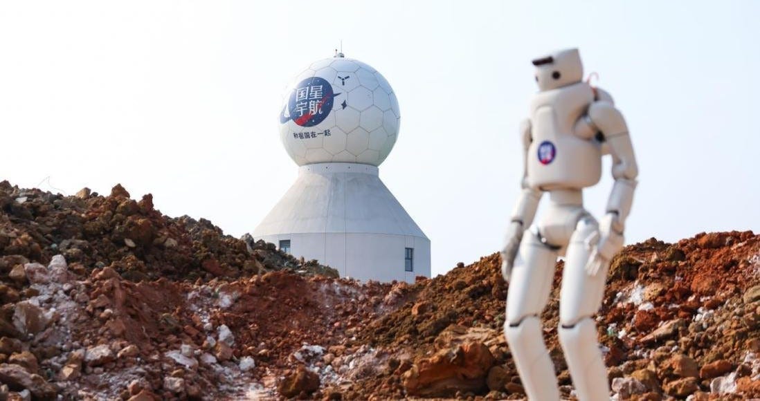 A bipedal robot surveying its surroundings after being given instructions from orbit by the Three-Body Computing Constellation.