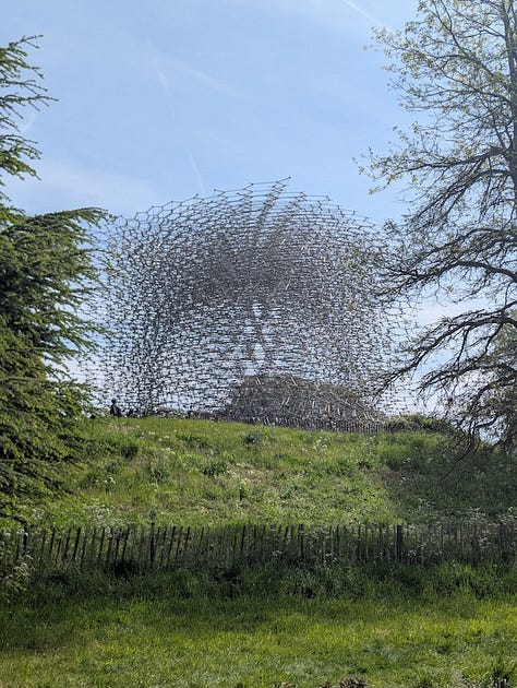 Three views of The Hive at Kew Gardens, a large aluminium lattice structure rising from a grassy landscape, shown from a distance, from beneath, and looking up through its circular interior.