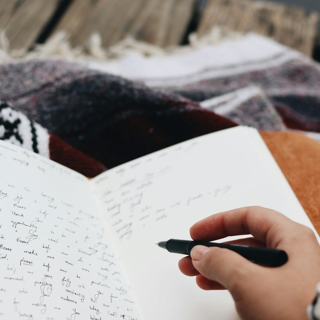person writing on white paper
