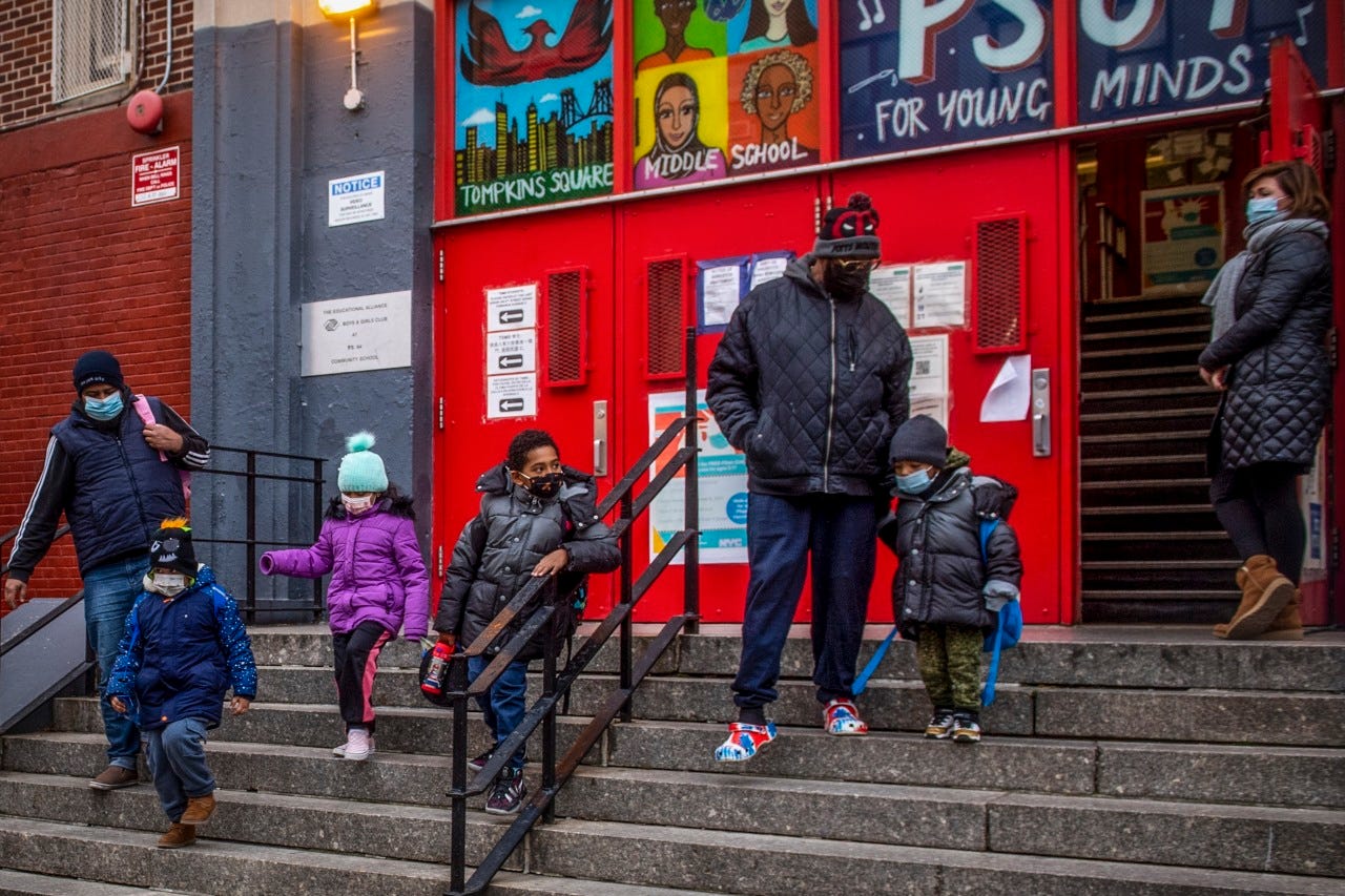 Children and their guardians wearing masks leave a Manhattan school, Dec. 21, 2021. Children and their guardians wearing masks leave a Manhattan school, Dec. 21, 2021.