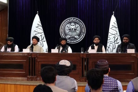 A group of people sitting at a podium

Description automatically generated with low confidence