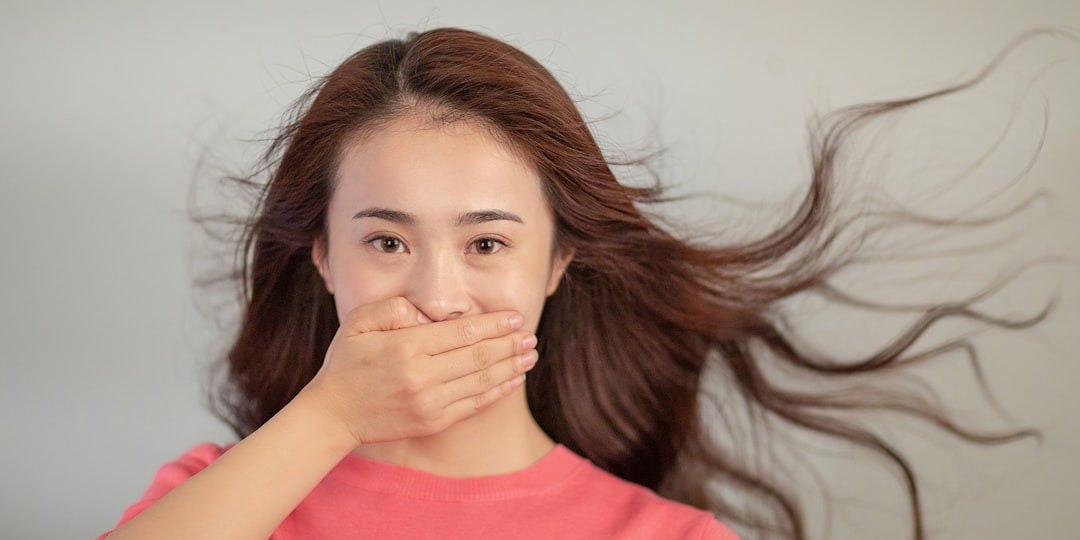 A woman covering her mouth with her hands