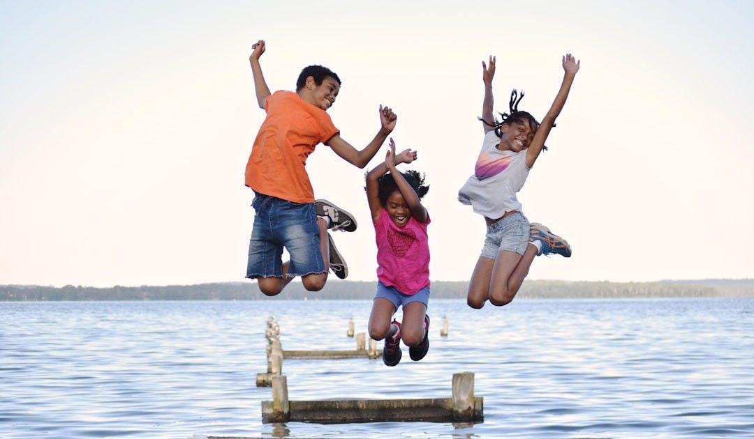 a group of people jumping on a dock