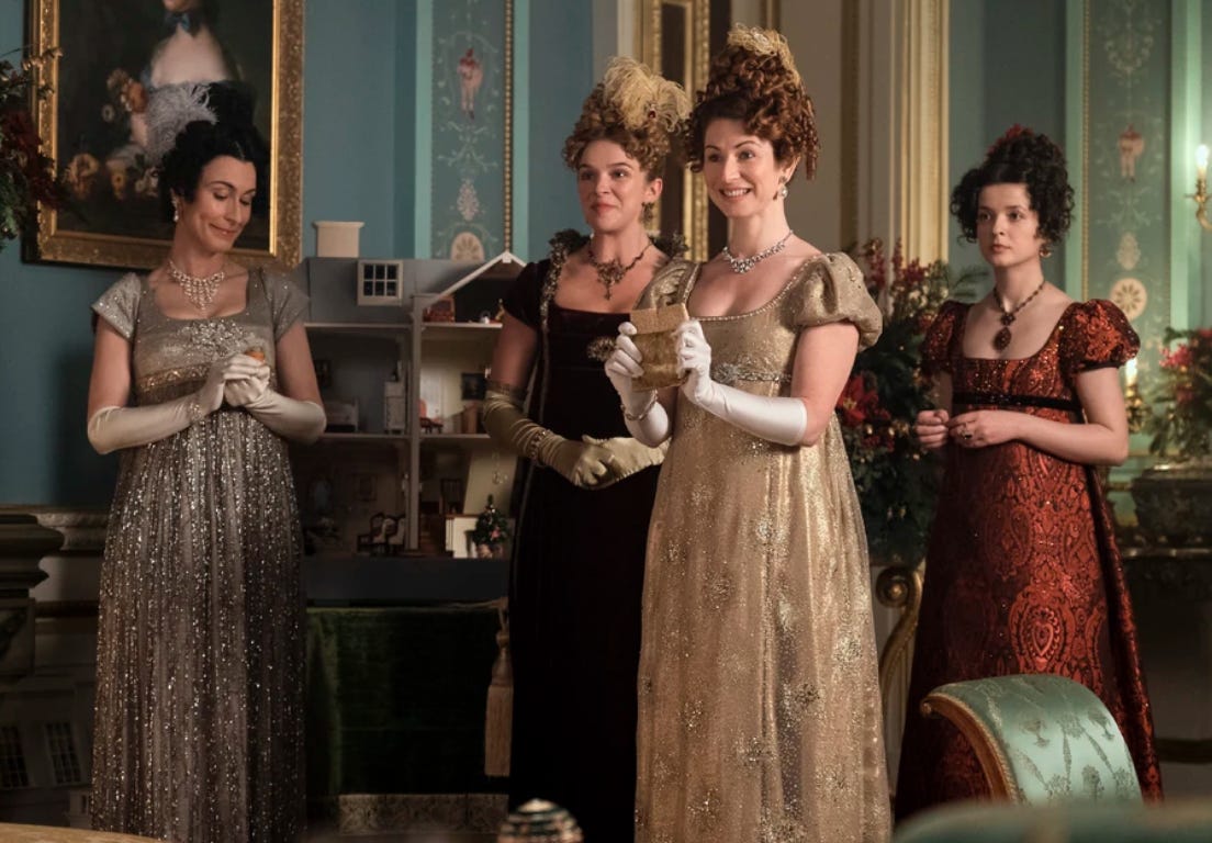 Four princesses standing in front of a dollhouse.