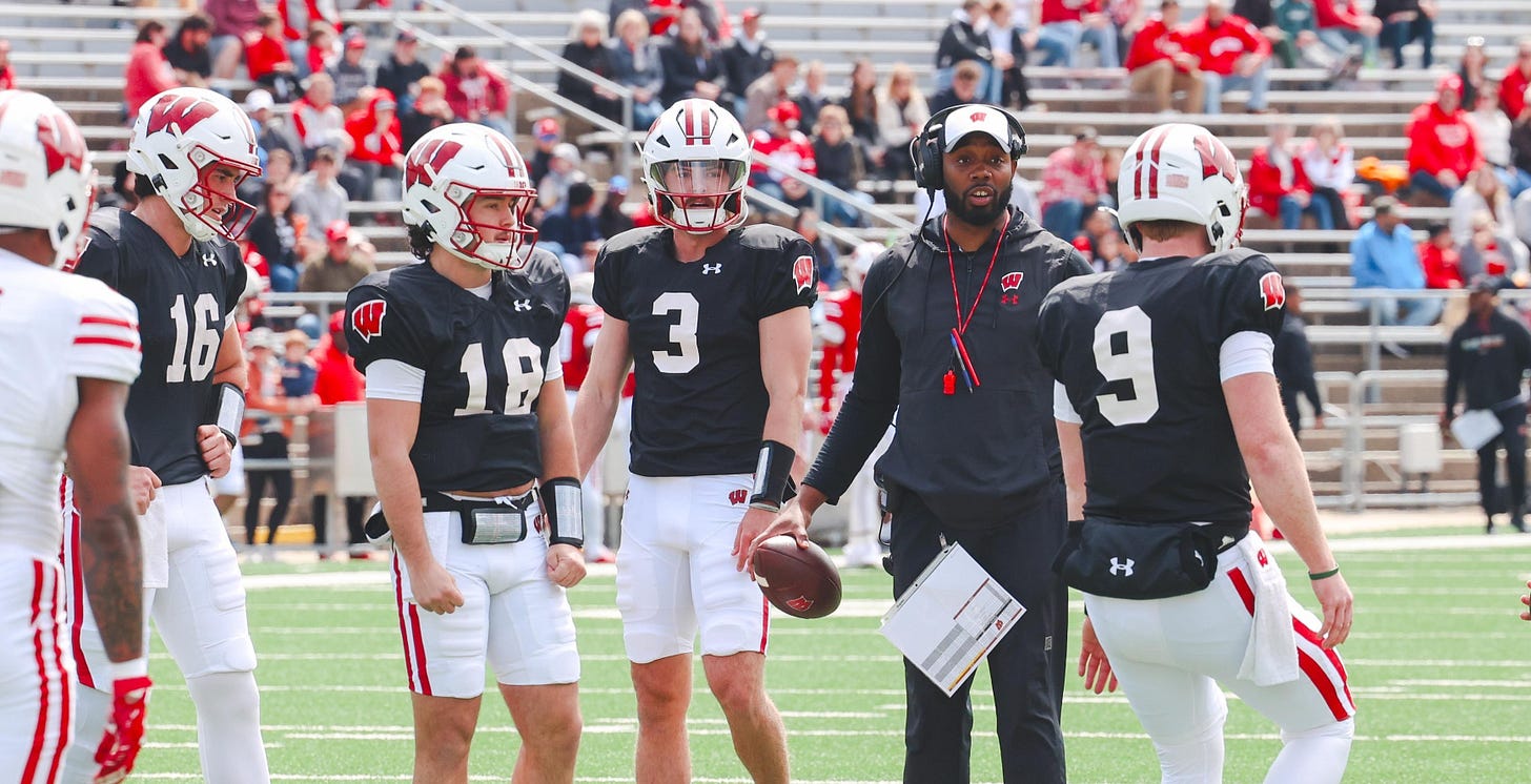 Kenny Guiton on the field at the Wisconsin Spring Showcase alongside quarterbacks Billy Edwards Jr., Danny O’Neil, and Carter Smith.