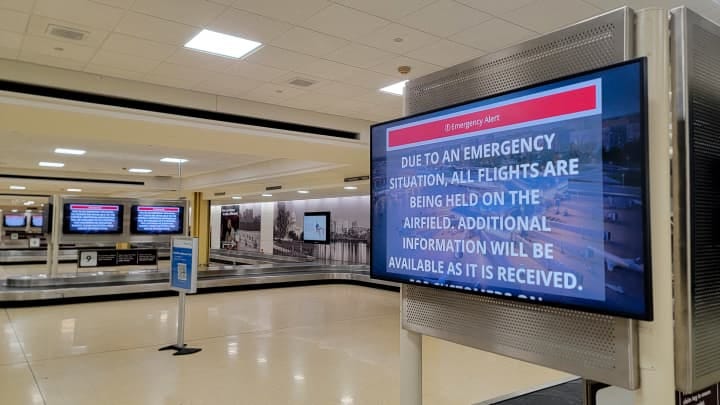 An information screen in Reagan National Airport's empty baggage claim area displays emergency instructions after a plane crashed into the Potomac River outside Washington, DC, Jan. 29, 2025.