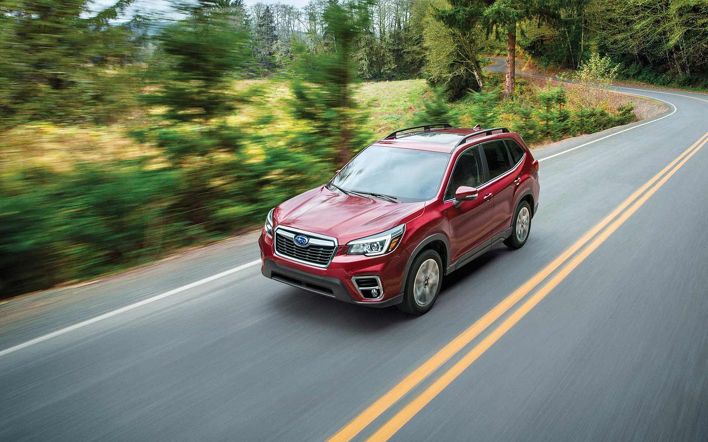 The 2020 Forester driving on a country highway. The 2020 Forester driving on a country highway.