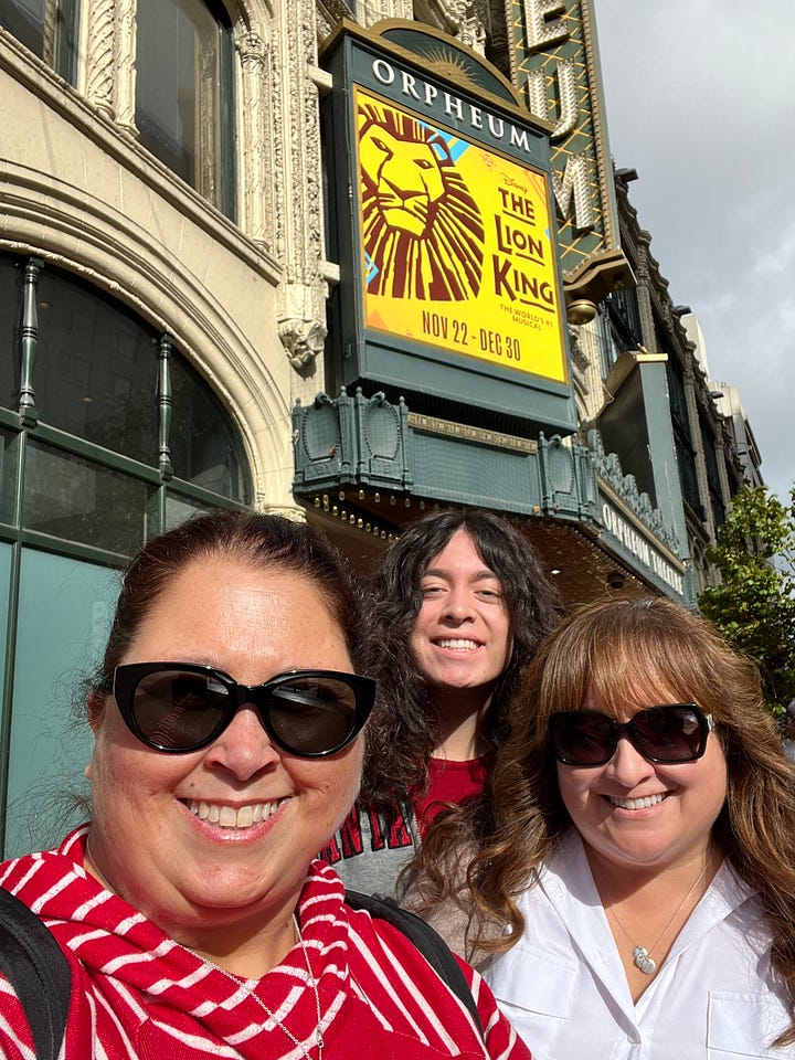 1: Image of Orpheum Theatre The Lion King marquee; 2: Image of 3 smiling people in front of The Lion King marquee; 3: Image of The Lion King playbill inside the theatre with the theatre curtain in the background; 4: image of 3 people - 1 with a mask, 2 without, in the theatre with the curtain behind them
