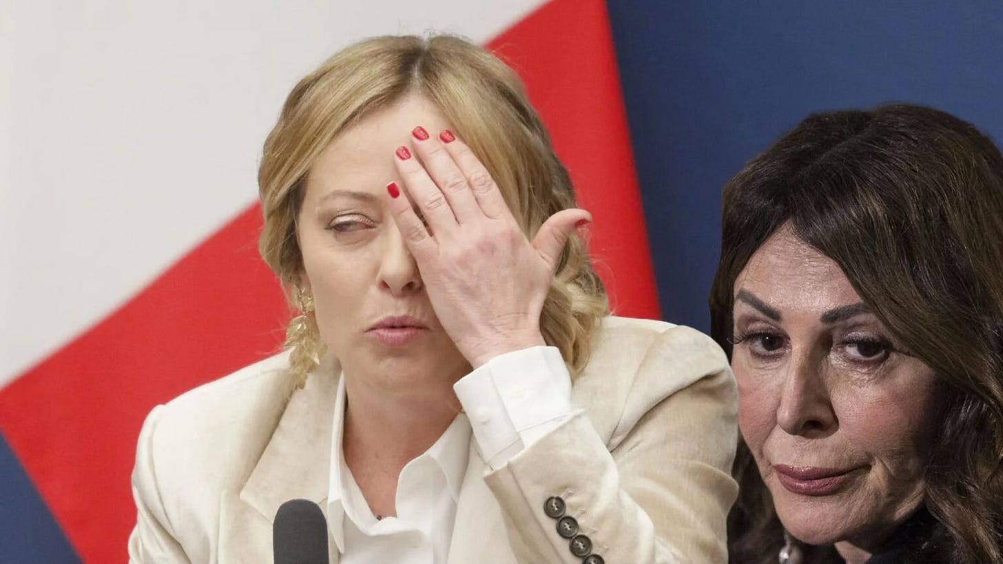 Giorgia Meloni si copre il volto accanto a Daniela Santanché durante una conferenza stampa di governo