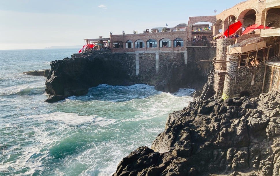 A stunning restaurant sits on the edge of a cliff over the ocean