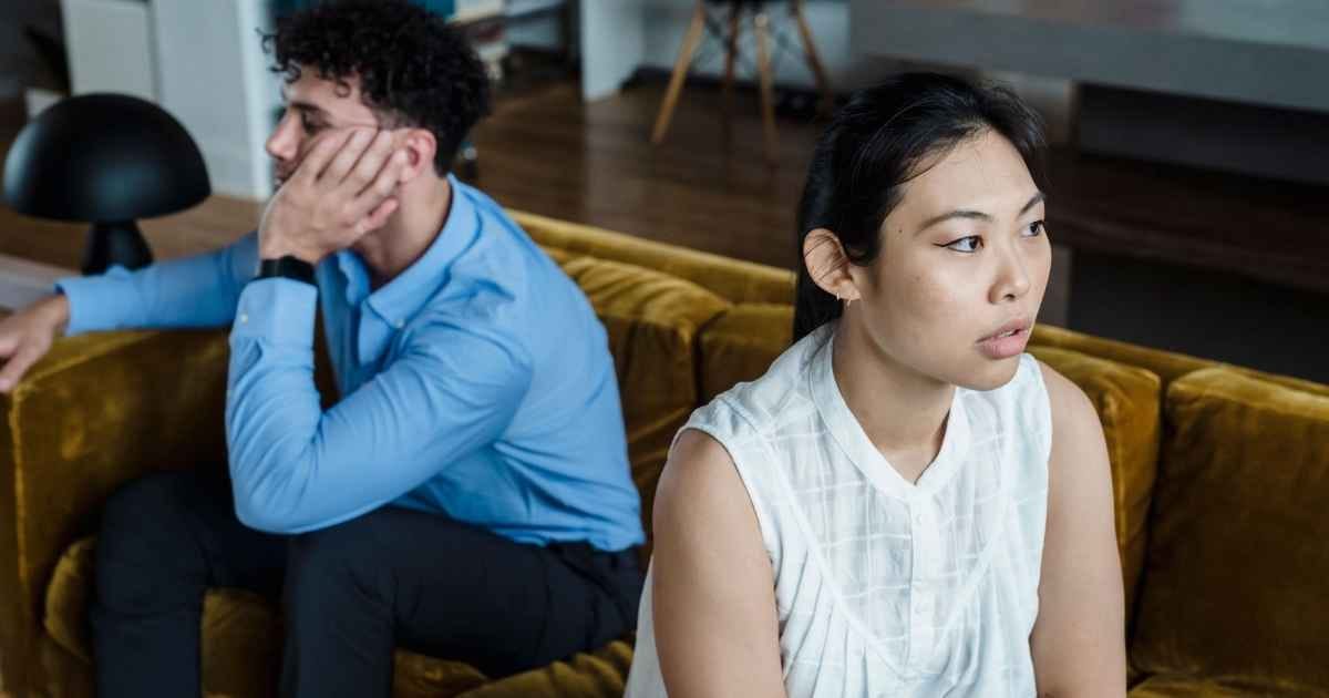 A serious moment between a couple sitting on a couch, highlighting tension and communication issues A serious moment between a couple sitting on a couch, highlighting tension and communication issues