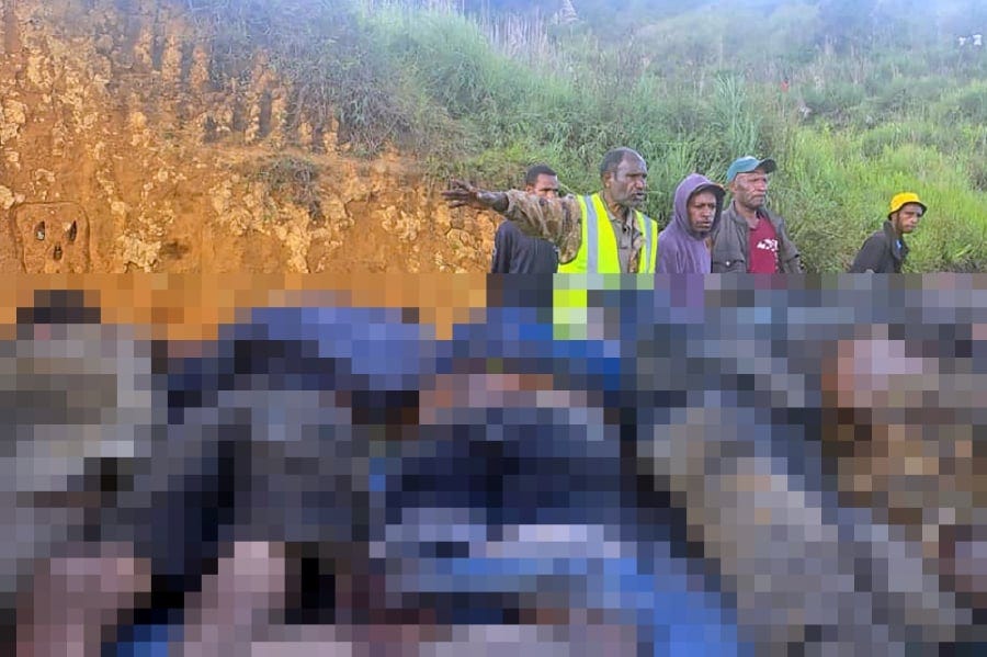 Officials removing dead bodies near the town of Wabag, 600 kilometres northwest of the capital Port Moresby. -AFP PIC