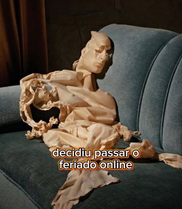 o que parece ser uma pele de um boneco inflável vazio, jogado em um sofá azul. Na base da imagem, a legenda: "decidiu passar o feriado online""