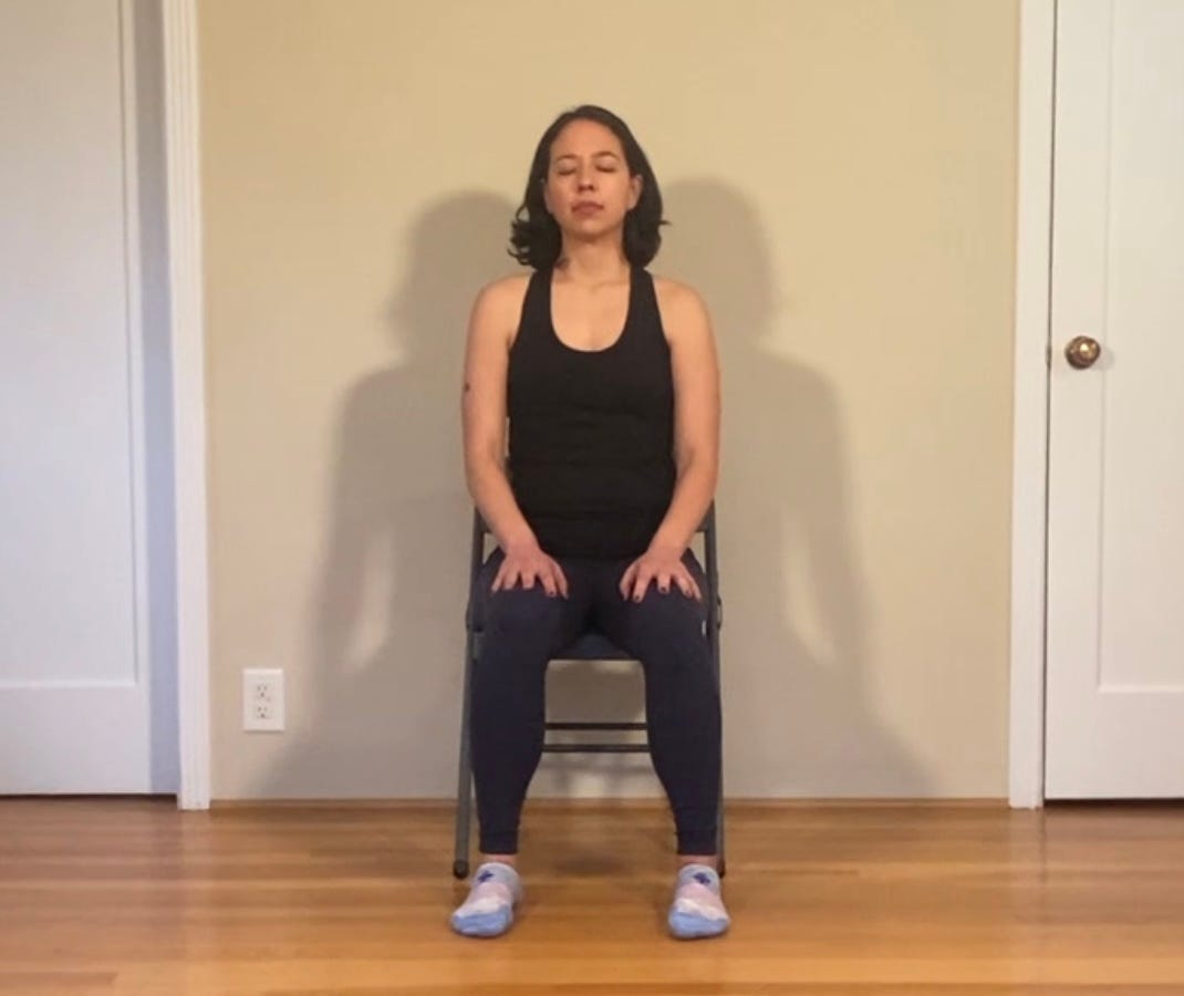 Woman sitting in a chair with eyes closed and feet on the floor
