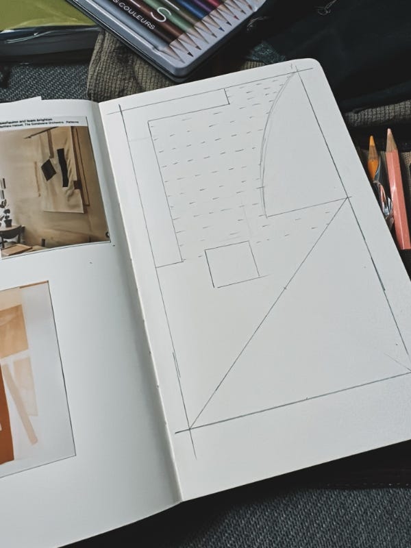 A sketchbook page with a penciled sketch of a quilt.